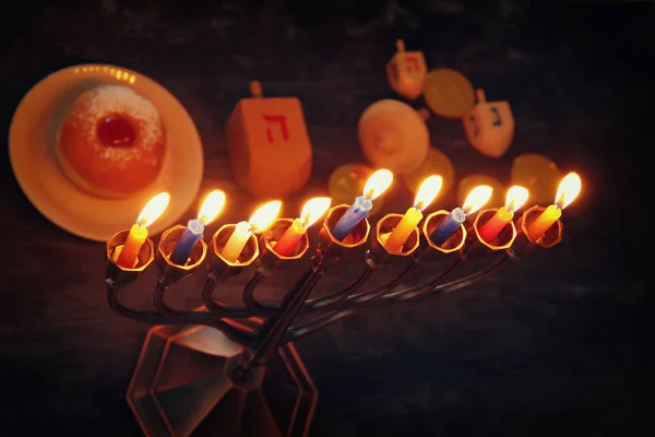 Jewish holiday Hanukkah background with traditional spinnig top, menorah (traditional candelabra) and burning candles — Stock Photo, Image