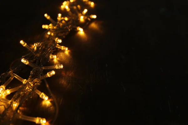 Balck 木製の背景にクリスマス温かみのあるゴールドのガーランド ライト — ストック写真
