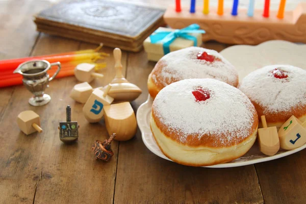 Bilden av judiska högtiden Hanukkah bakgrund med traditionella spinnig topp och munkar. — Stockfoto