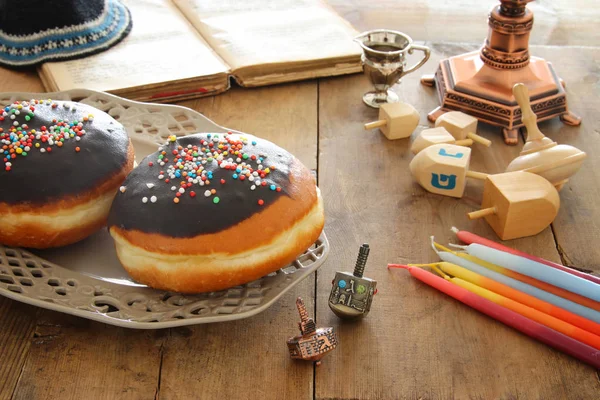 Bilden av judiska högtiden Hanukkah bakgrund med traditionella spinnig topp och munkar. — Stockfoto