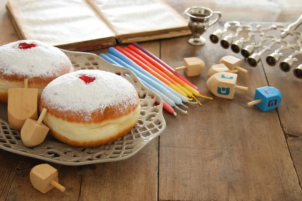 jewish holiday Hanukkah background with traditional spinnig top, doughnuts and menorah (traditional candelabra).