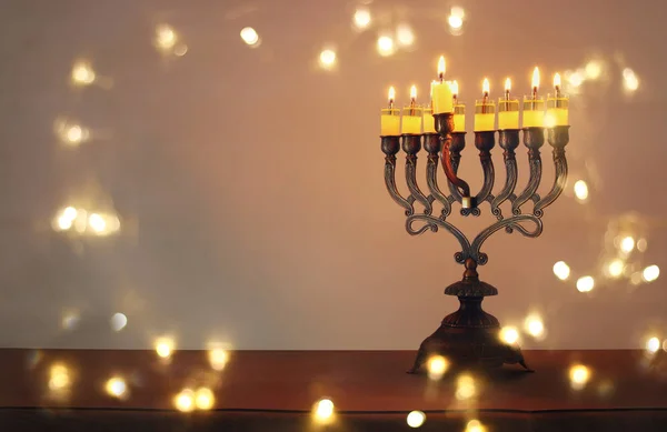 Låg nyckel bild av judiska högtiden Hanukkah bakgrund med menorah (traditionella kandelabrar) och brinnande ljus — Stockfoto