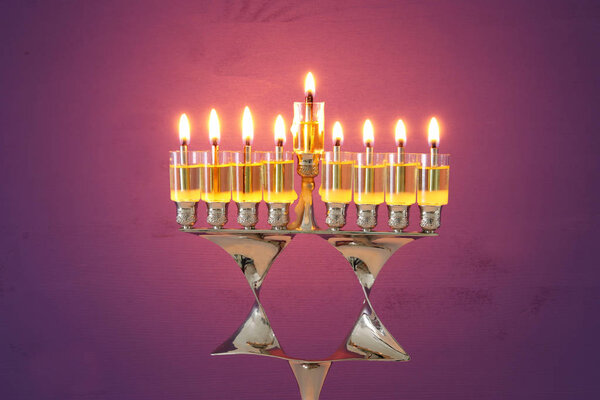 image of jewish holiday Hanukkah background with menorah (traditional candelabra) and burning candles.