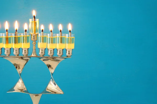 image of jewish holiday Hanukkah background with menorah (traditional candelabra) and burning candles.