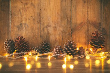 Tatil görüntü ile Noel altın çelenk ışık ve çam kozalakları ahşap arka plan üzerinde