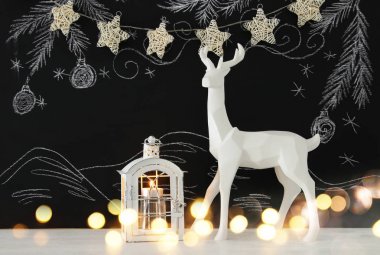 Kara tahta arka plan whith el üzerinde ahşap masa üzerinde beyaz Ren geyiği tebeşir illüstrasyonlar çizilmiş