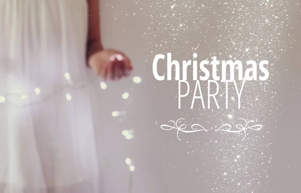 Obraz Abstrakcja i bokeh młoda kobieta gospodarstwa wianek światła Bożego Narodzenia i typography: Christmas Party. Wakacje zaproszenie koncepcja. — Zdjęcie stockowe