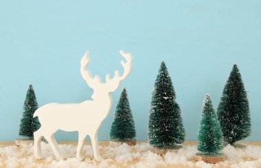 Görüntü Noel ağaçları ve karlı ahşap masa üzerinde Ren geyiği