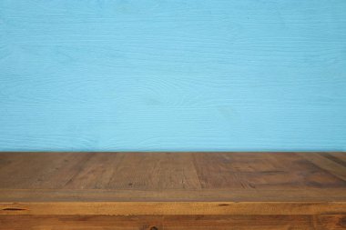 Mavi ahşap arka plan önünde boş bir tablo. Ürün görüntü montaj için