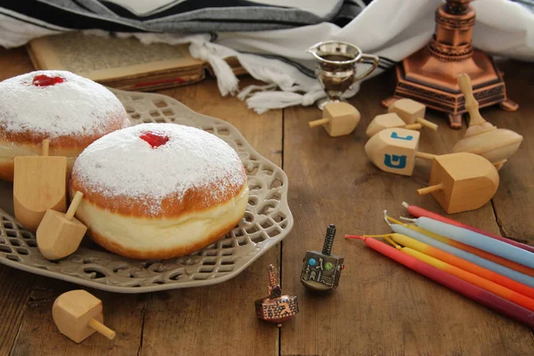 Bilden av judiska högtiden Hanukkah bakgrund med traditionella spinnig topp och munkar. — Stockfoto