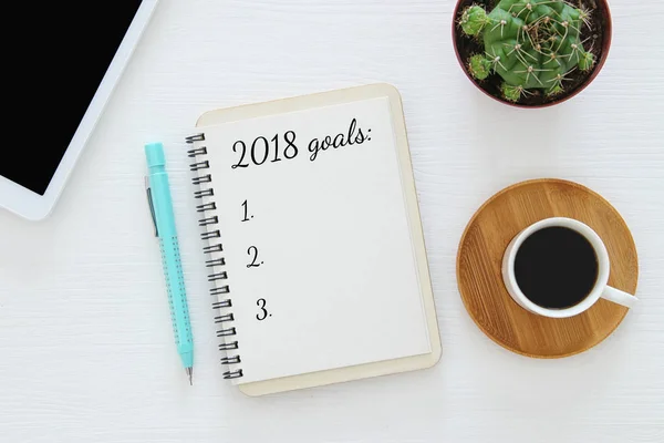 Top view 2018 goals list with notebook, cup of coffee on wooden desk. — Stock Photo, Image