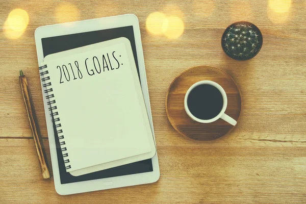 Top view 2018 goals list with notebook, cup of coffee on wooden desk. — Stock Photo, Image