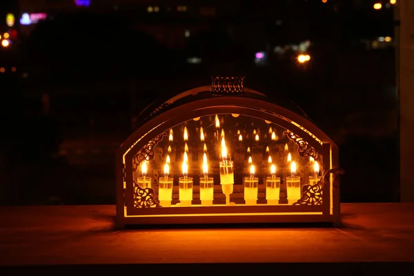 Image of jewish holiday Hanukkah background with menorah (traditional candelabra) and burning candles in front of the window. — Stock Photo, Image