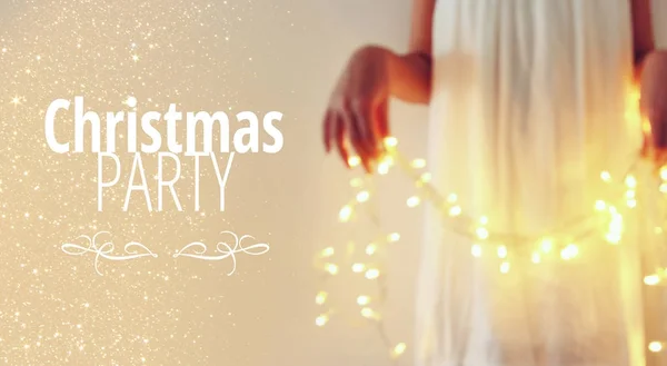 Imagem abstrato e bokeh da jovem segurando luzes guirlanda natal e tipografia: CHRISTMAS PARTY. Conceito de convite de férias . — Fotografia de Stock