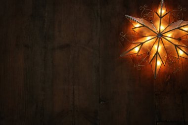 Noel yıldızı ahşap arka plan üzerinde parlayan resim.