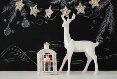 Kara tahta arka plan whith el üzerinde ahşap masa üzerinde beyaz Ren geyiği tebeşir illüstrasyonlar çizilmiş