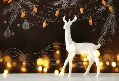 Ahşap masa üzerinde el ile kara tahta arka plan üzerinde beyaz Ren geyiği tebeşir illüstrasyonlar çizilmiş.