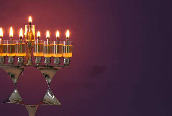image of jewish holiday Hanukkah background with menorah (traditional candelabra) and candles.
