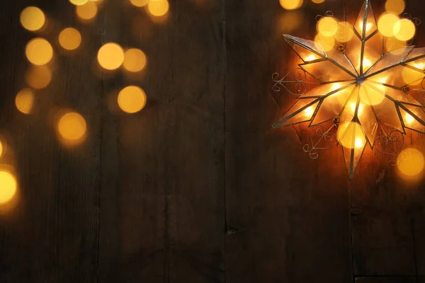 Εικόνα των Χριστουγέννων που λάμπει το αστέρι πέρα από το ξύλινο υπόβαθρο. — Φωτογραφία Αρχείου