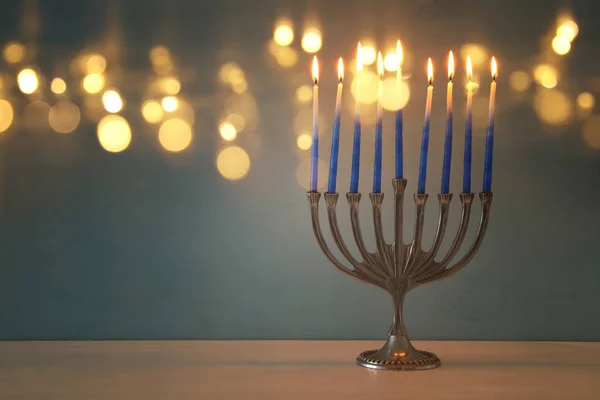 image of jewish holiday Hanukkah background with traditional menorah (traditional candelabra) and burning candles