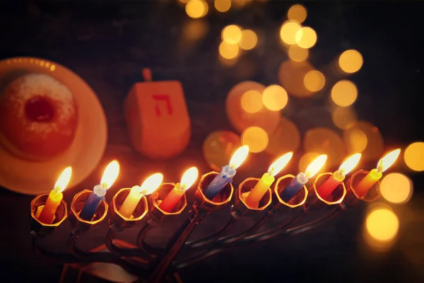 Jewish holiday Hanukkah background with traditional spinnig top, menorah (traditional candelabra) and burning candles — Stock Photo, Image