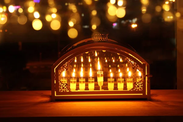 Imagem de feriado judaico Hanukkah fundo com menorah (candelabro tradicional) e velas em chamas na frente da janela . — Fotografia de Stock