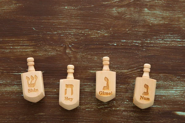 Obrázek je židovský svátek Chanuka s dřevěnými dreidels collection (Káča) na stole — Stock fotografie