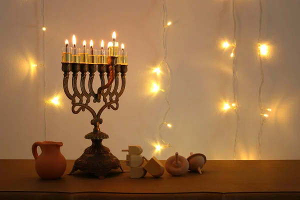 Immagine low key di festa ebraica Hanukkah sfondo con tradizionale spinnig top, menorah (candelabro tradizionale ) — Foto Stock