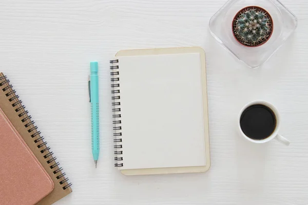 Vista superior do caderno aberto com páginas em branco ao lado da xícara de café na mesa de madeira. pronto para adicionar texto ou mockup — Fotografia de Stock