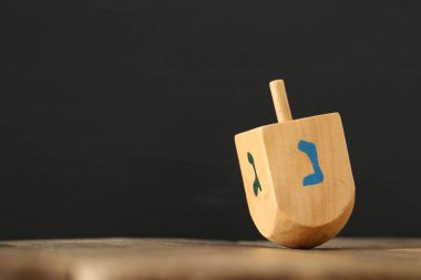 jewish holiday Hanukkah with wooden dreidels colection (spinning top) on the table clipart