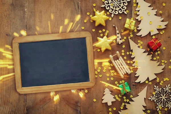 Vista dall'alto immagine di Natale decorazioni festive accanto alla lavagna vuota su vecchio sfondo di legno — Foto Stock