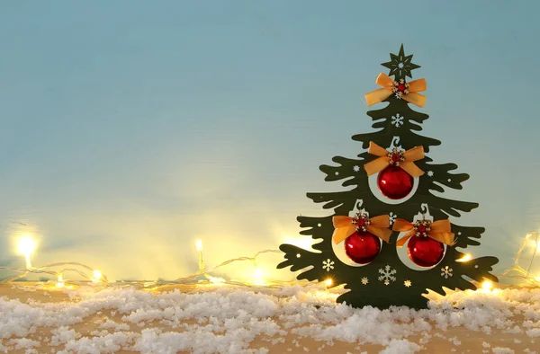 Obrázek vánočního stromu s míč ozdoby na zasněžené dřevěný stůl. — Stock fotografie