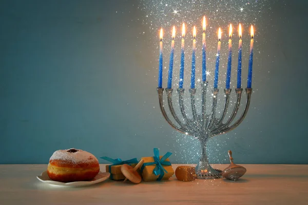 Jewish holiday Hanukkah background with traditional spinnig top, menorah (traditional candelabra) and burning candles — Stock Photo, Image