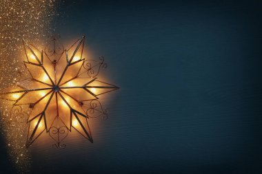 Noel yıldızı ahşap arka plan üzerinde parlayan resim.