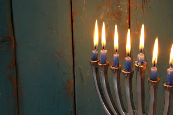 image of jewish holiday Hanukkah background with menorah (traditional candelabra) and candles.