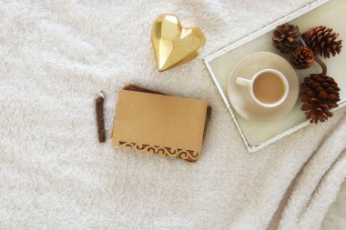 Boş Not ve fincan kapuçino rahat ve sıcak kürk halı üzerinde. Üstten Görünüm.