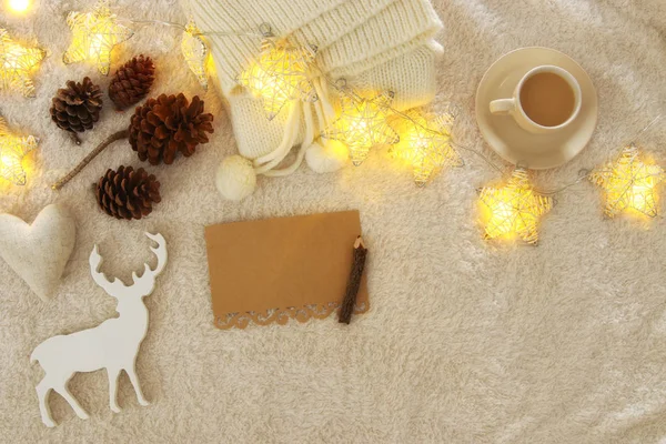 Empty note and cup of cappuccino over cozy and warm fur carpet. Top view. — Stock Photo, Image