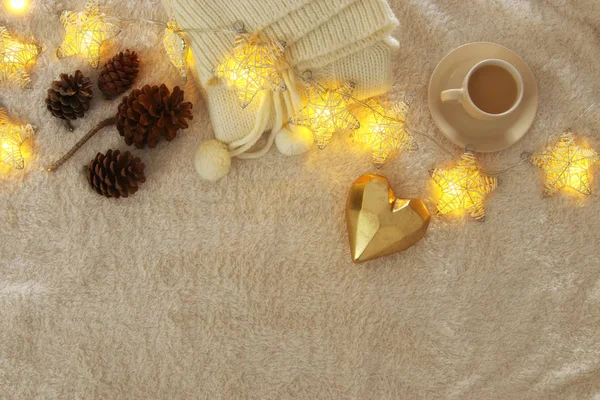 Pine cones and cup of cappuccino over cozy and fur carpet. Top view. — Stock Photo, Image
