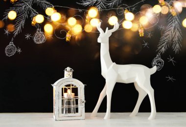 Ahşap masa üzerinde el ile kara tahta arka plan üzerinde beyaz Ren geyiği tebeşir illüstrasyonlar çizilmiş.