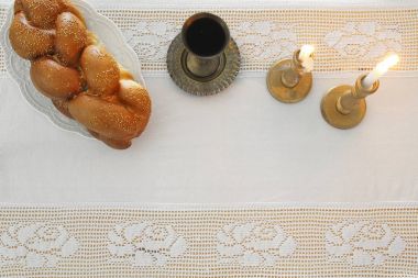 shabbat image. challah bread, shabbat wine and candles on the table. Top view. clipart