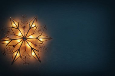 Noel yıldızı ahşap arka plan üzerinde parlayan resim.