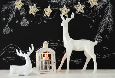 Kara tahta arka plan whith el üzerinde ahşap masa üzerinde beyaz Ren geyiği tebeşir illüstrasyonlar çizilmiş