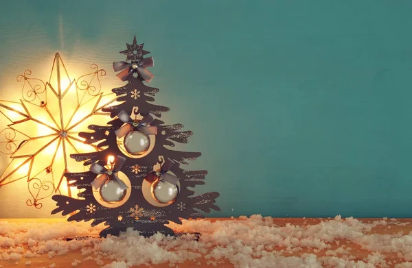 Image de sapin de Noël avec des décorations de boule sur une table en bois enneigée . — Photo