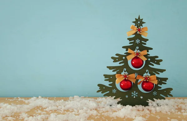 Imagen del árbol de Navidad con decoraciones de bolas en la mesa de madera nevada . —  Fotos de Stock