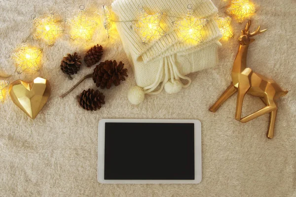 Cup of coffee next to tablet device with empty screen over cozy and warm fur carpet. Top view. — Stock Photo, Image