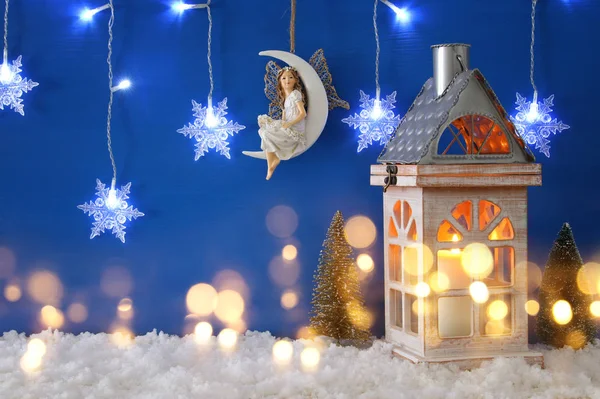 Weihnachtsbäume, alte Laterne, Schneeflocken Silbergirlanden Licht, Fee auf dem Mond über dem Schnee und blauem Hintergrund. — Stockfoto
