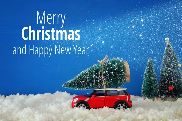 Rotes Auto Das Einen Weihnachtsbaum Mit Lichtergirlanden Uber Den Schnee Tragt Stockfoto C Tomert