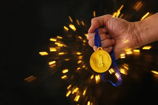 Mann Hält Goldmedaille Vor Schwarzem Hintergrund Mit Feuerwerkskörper Der Hand — Stockfoto
