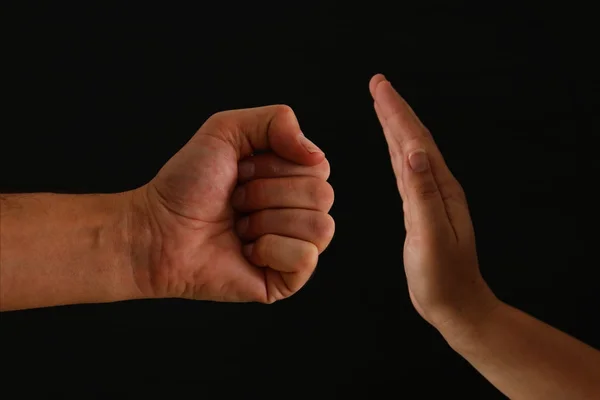 Obrázek mužské pěsti a ženské ruky ukazující Stop. Pojem domácí násilí na ženách. — Stock fotografie
