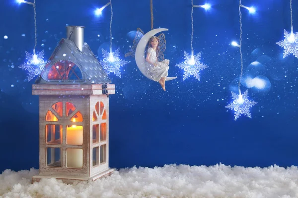 Wooden old house with candle and fairy on the moon over the snow and blue background. — Stock Photo, Image